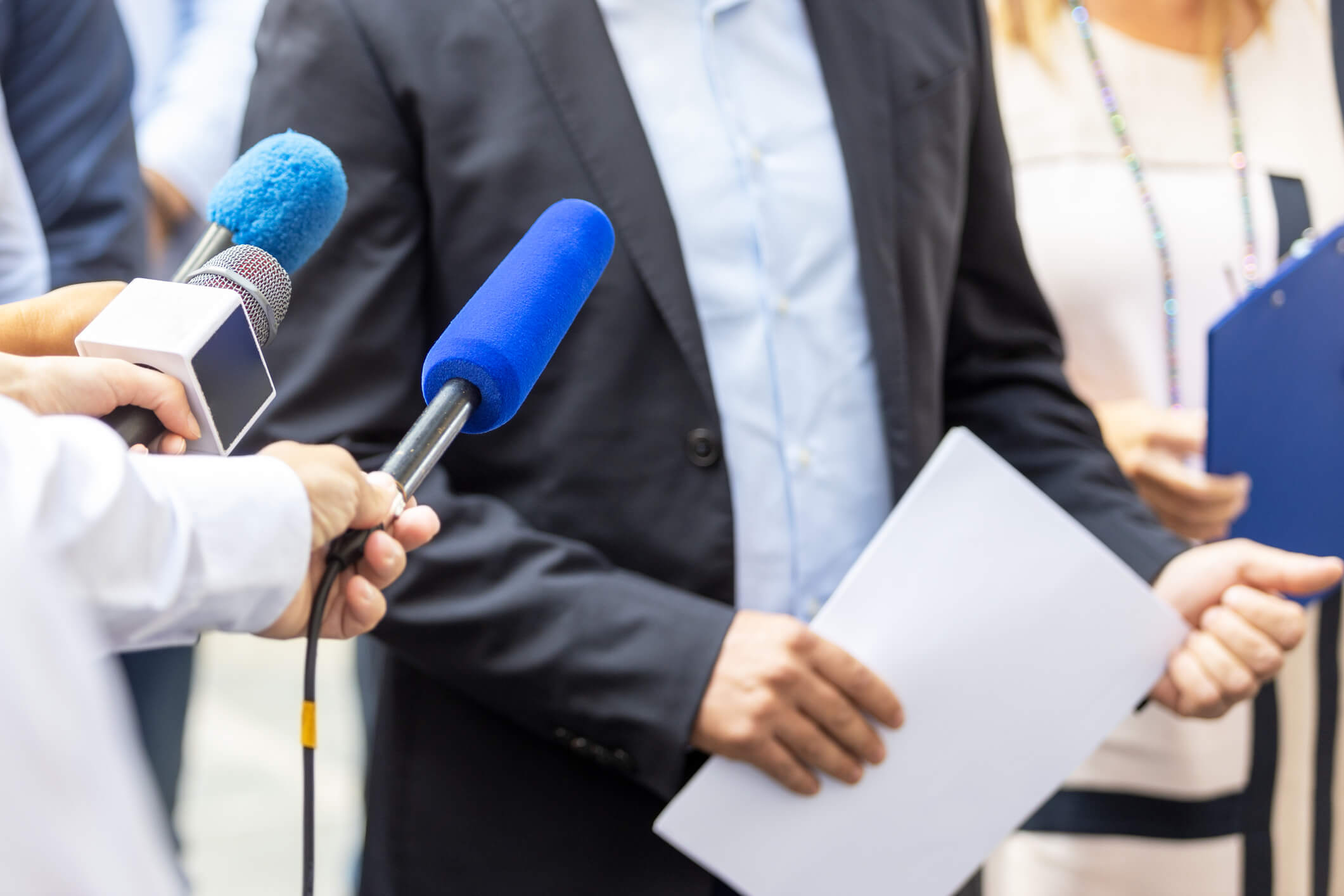 Hand holding microphone with blue sponge